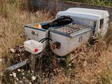 a white truck with a trailer attached to it in a field
