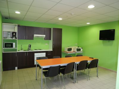 a room with a table, chairs and a television in it