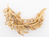 a close up of a gold broochle with leaves on it