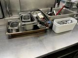 stainless steel counter top with dishes and utensils in a commercial kitchen