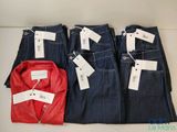 Trois paires de jeans pour homme et une chemise rouge sont exposées