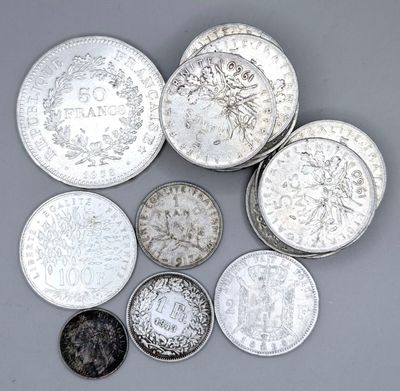 six types différents de pièces d'argent sur une surface grise