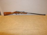 un fusil posé sur une table près d'un mur
