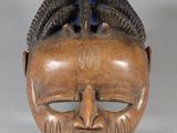 une image représentant un masque en bois sur un fond blanc