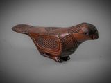 a close up of a small wooden bird on a table