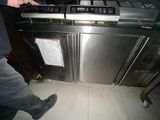 a man standing next to an oven in a kitchen