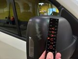 a person holding a ruler in front of a car