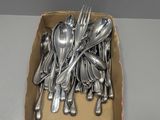 une boîte contenant des cuillères et des fourchettes en argent posée sur une table