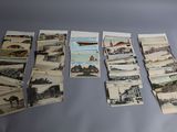 un grand nombre de cartes postales anciennes qui se trouvent sur la table