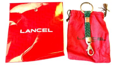 a red bag with a green rope and a red bag with a lancel on it