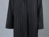 un manteau noir à col de fourrure sur un mannequin