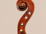 a close up of the back of a violin with a fiddle in the foreground