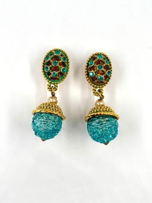 a pair of turquoise and gold earrings on a white background