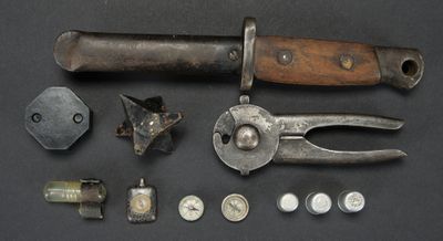 un couteau, une pince, des écrous, des vis et d'autres objets posés sur une table