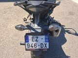 une moto garée sur un parking et munie d'une plaque d'immatriculation
