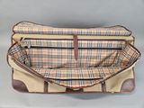 the brown and tan plaid bag is open on a white surface