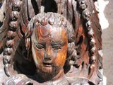 a wooden sculpture of a man with a bird on his head