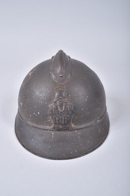 un petit casque métallique posé sur une surface blanche