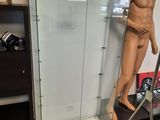 un mannequin dans une vitrine, dans une pièce