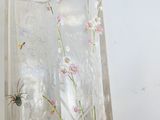 a glass vase with flowers and a spider on it