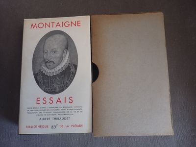 un vieux livre posé sur une table, à côté d'une photo en noir et blanc