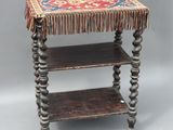 an old wooden table with a colorful rug on top of it
