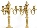 trois chandeliers dorés avec des bougies sur fond blanc