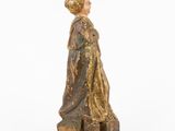 a wooden statue of a woman in a dress and hat