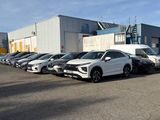 de nombreuses voitures garées sur un parking situé devant un immeuble