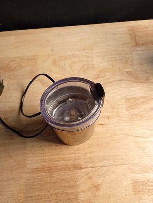 un mixeur posé sur une table à côté d'une tasse