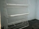 a white shelf in the corner of a room