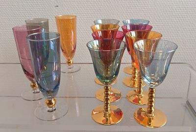 de nombreux verres à vin de différentes couleurs posés sur une table en verre