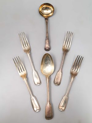 Plusieurs fourchettes et cuillères sont disposées en cercle sur une table