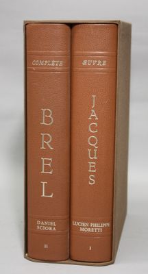 two brown books sitting on top of each other on a white surface