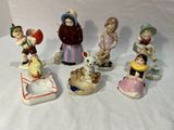 cinq figurines d'enfants assis sur une surface blanche