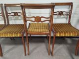 three antique chairs with striped upholstered seats in a room