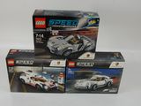 trois voitures de course Lego dans leurs boîtes, posées sur une surface blanche