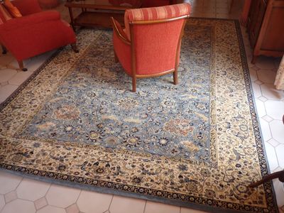 un grand tapis avec une chaise rouge au milieu