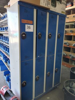 blue lockers in a warehouse with a lot of shelves and bins in the background