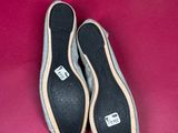 a pair of black and white shoes on a pink surface