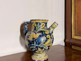 un vase bleu et jaune posé sur un parquet