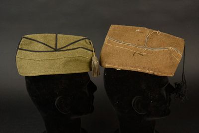 deux mannequins noirs portant des chapeaux ornés de pompons