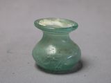un vase en verre vert percé d'un petit trou