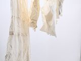 two dresses hanging on a clothes rack in a room