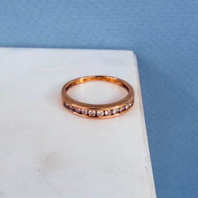 une photo d'une bague en or sertie de pierres roses