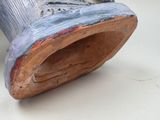 a close up of a wooden shoe with a bird on top of it