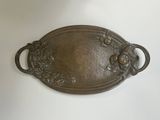 une plaque métallique ornée de fleurs et de feuilles