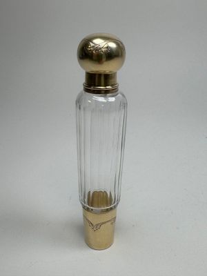 an image of a small glass bottle with a gold top