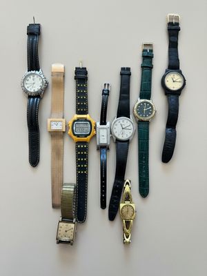 many different types of watches displayed on a table