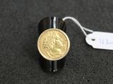 Gros plan sur une bague ornée d'une pièce d'or